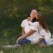 A joyful moment between mother and daughter hugging on a grassy field.